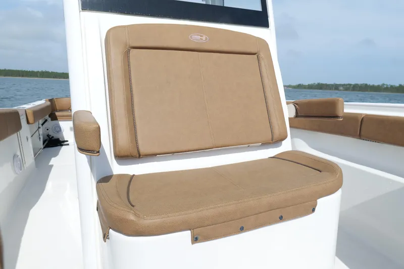 Slide: The Image of 2021 Sea Hunt Ultra 305 SE boat with tan seating, on calm water. - 28