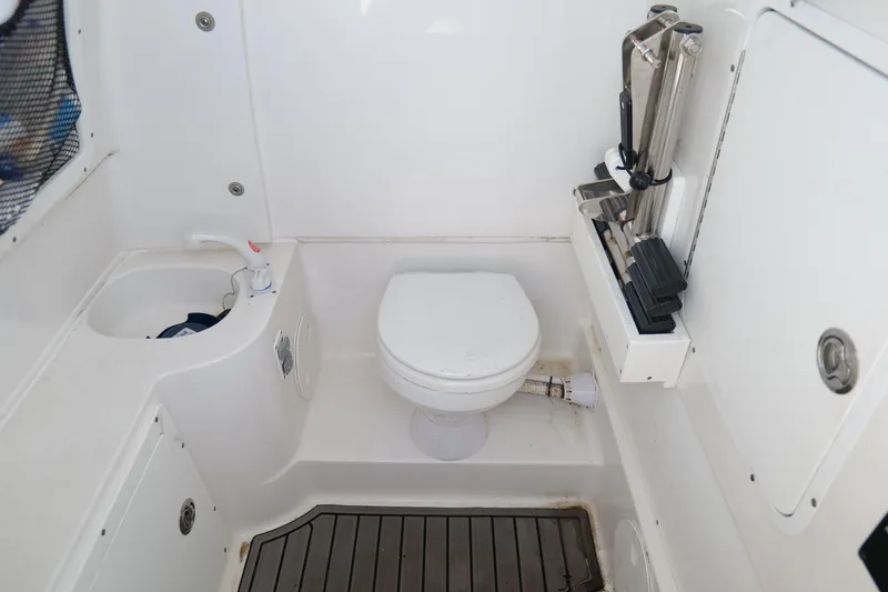 Slide: The Image of Interior of 2021 Sea Hunt Ultra 305 SE boat featuring a compact marine toilet. - 32