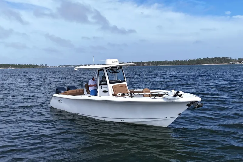Slide: The Image of 2021 Sea Hunt Ultra 305 SE boat cruising on open water under a clear sky. - 7