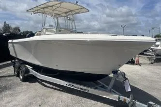 Slide: The Image of 2022 Sailfish 242 CC boat on trailer under cloudy sky. - 2