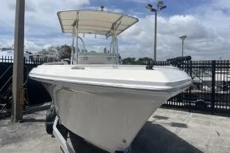 Slide: The Image of 2022 Sailfish 242 CC boat with canopy, docked outdoors under a cloudy sky. - 4