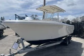 Slide: The Image of 2022 Sailfish 242 CC boat on trailer, parked outdoors under cloudy sky. - 5