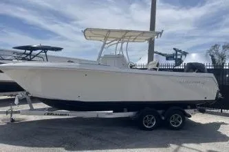 Slide: The Image of 2022 Sailfish 242 CC boat on trailer, parked outdoors under a cloudy sky. - 6