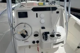 Slide: The Image of 2022 Sailfish 242 CC boat console with steering wheel, controls, and navigation equipment. - 8