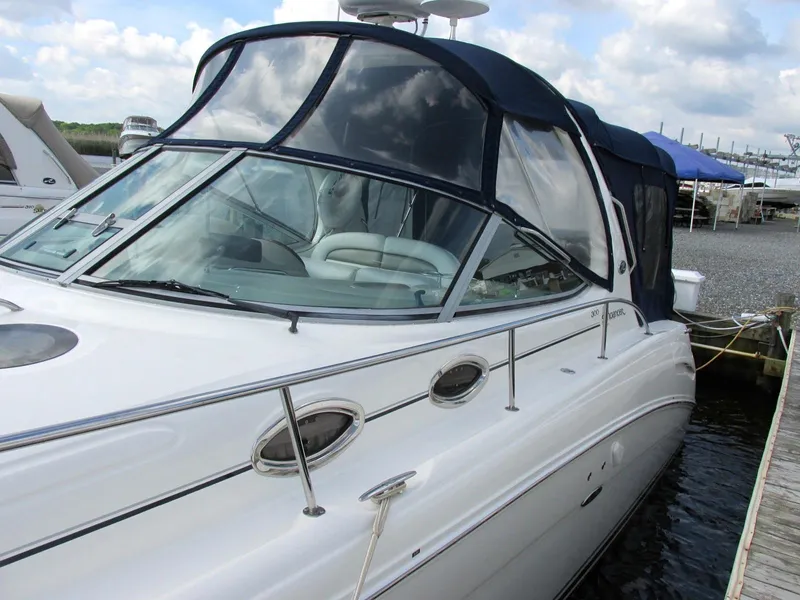 The Image of 2006 Sea Ray 300 Sundancer docked, featuring canopy and clear windshield. - 0
