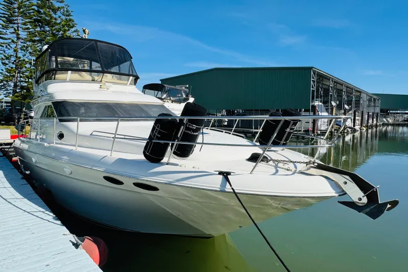 Slide: The Image of 2000 Sea Ray 400 Sedan Bridge yacht docked at marina under clear blue sky. - 12