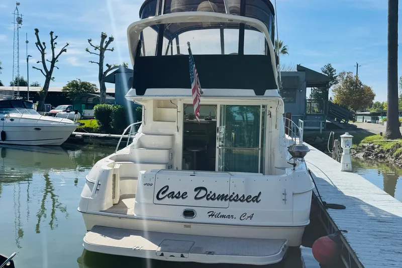 Slide: The Image of 2000 Sea Ray 400 Sedan Bridge yacht docked, rear view with "Case Dismissed" nameplate. - 13