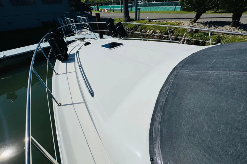 Slide: The Image of 2000 Sea Ray 400 Sedan Bridge yacht docked, showcasing sleek deck design and railing. - 16