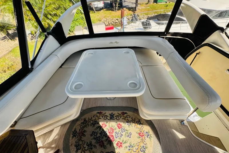 Slide: The Image of Interior of 2000 Sea Ray 400 Sedan Bridge with white seating and table. - 25