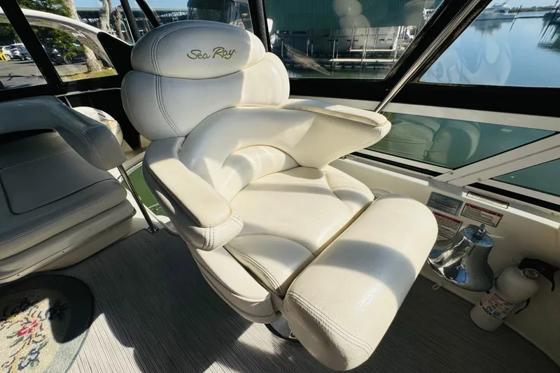 Slide: The Image of Captain's chair on a 2000 Sea Ray 400 Sedan Bridge yacht, featuring luxurious white leather upholstery. - 26
