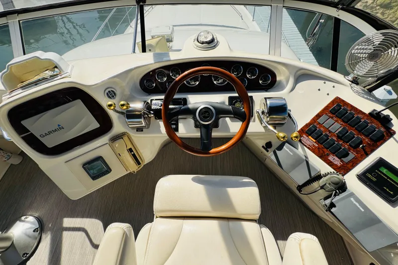 Slide: The Image of Cockpit of 2000 Sea Ray 400 Sedan Bridge with Garmin navigation system and wooden steering wheel. - 29
