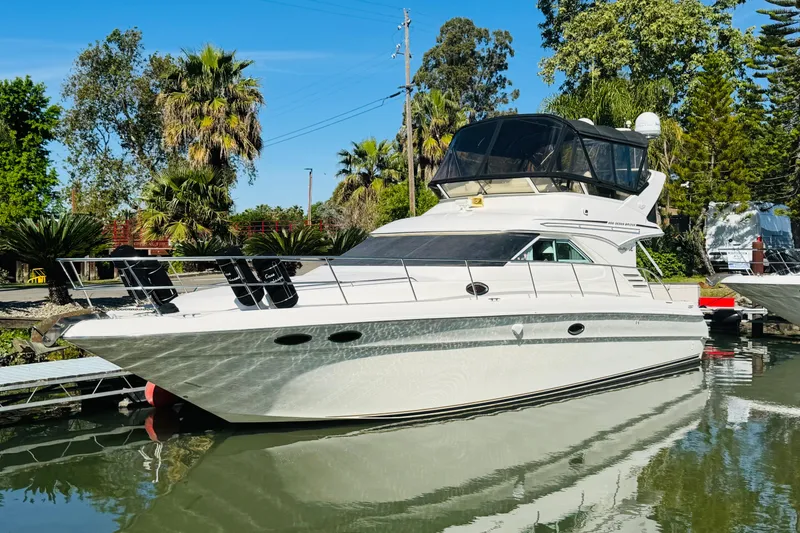 Slide: The Image of 2000 Sea Ray 400 Sedan Bridge yacht docked in a scenic marina setting. - 3