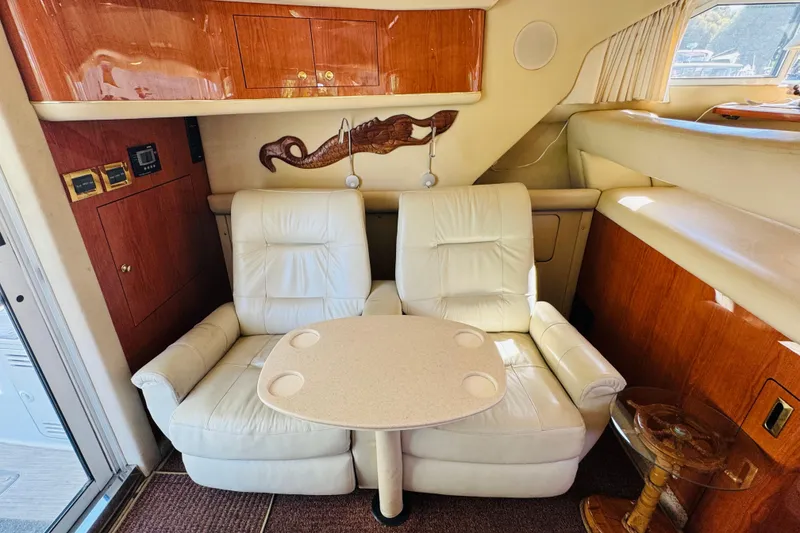 Slide: The Image of Interior of 2000 Sea Ray 400 Sedan Bridge with white leather seating and wooden cabinetry. - 39