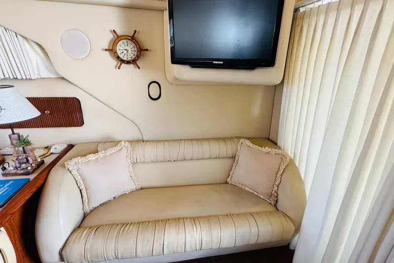 Slide: The Image of Interior of 2000 Sea Ray 400 Sedan Bridge with sofa, TV, and nautical decor. - 43