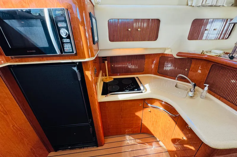 Slide: The Image of Luxurious kitchen interior of 2000 Sea Ray 400 Sedan Bridge yacht with wood finish. - 47