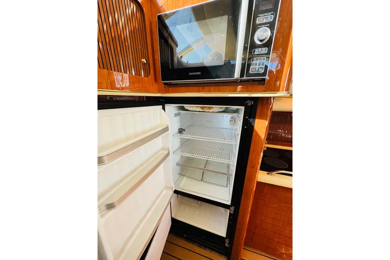 Slide: The Image of Microwave and open fridge in 2000 Sea Ray 400 Sedan Bridge yacht kitchen. - 48