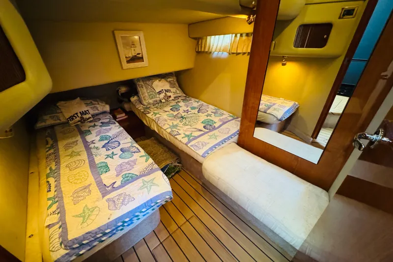 Slide: The Image of Interior cabin of 2000 Sea Ray 400 Sedan Bridge with twin beds and nautical decor. - 52