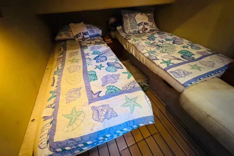 Slide: The Image of Twin beds with nautical-themed bedding in a 2000 Sea Ray 400 Sedan Bridge cabin. - 53