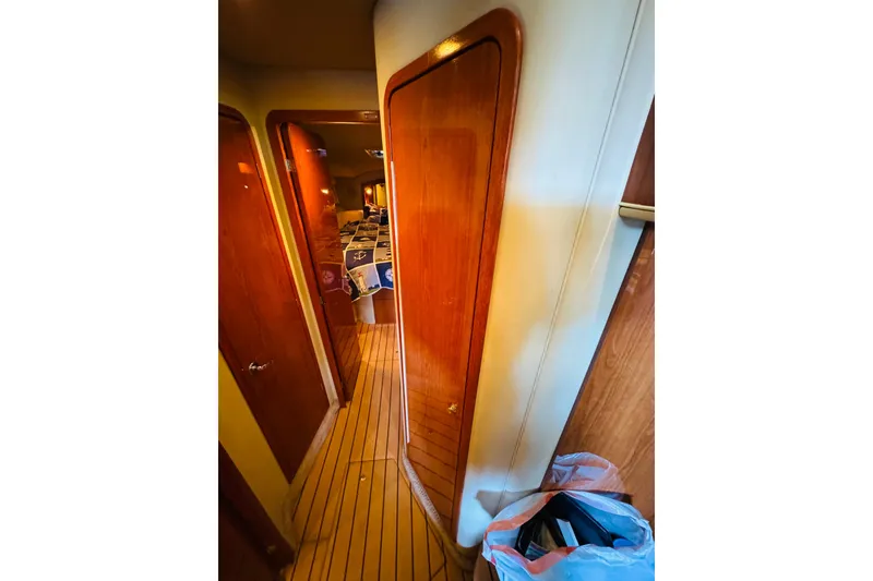 Slide: The Image of Interior hallway of 2000 Sea Ray 400 Sedan Bridge yacht with wooden doors and flooring. - 59