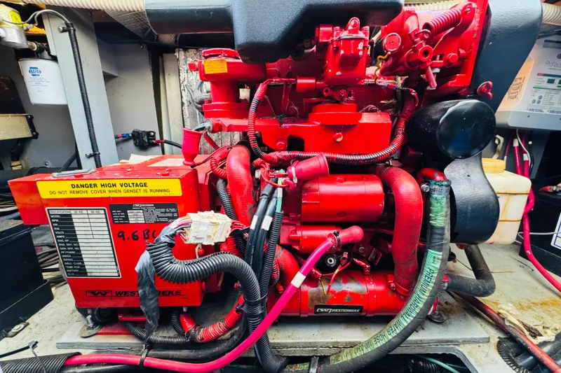 Slide: The Image of Engine room of a 2000 Sea Ray 400 Sedan Bridge with a red Westerbeke generator. - 73
