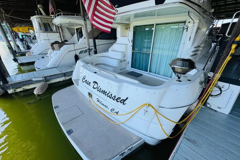 Slide: The Image of 2000 Sea Ray 400 Sedan Bridge docked, featuring "Case Dismissed" name and American flag. - 9
