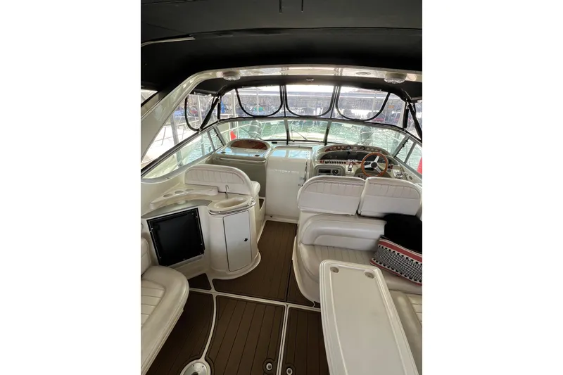 Slide: The Image of 1998 Maxum 4100 SCR yacht interior with white seating and wooden steering wheel. - 13