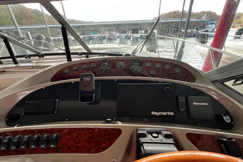 Slide: The Image of 1998 Maxum 4100 SCR boat dashboard with Raymarine electronics and smartphone holder. - 6