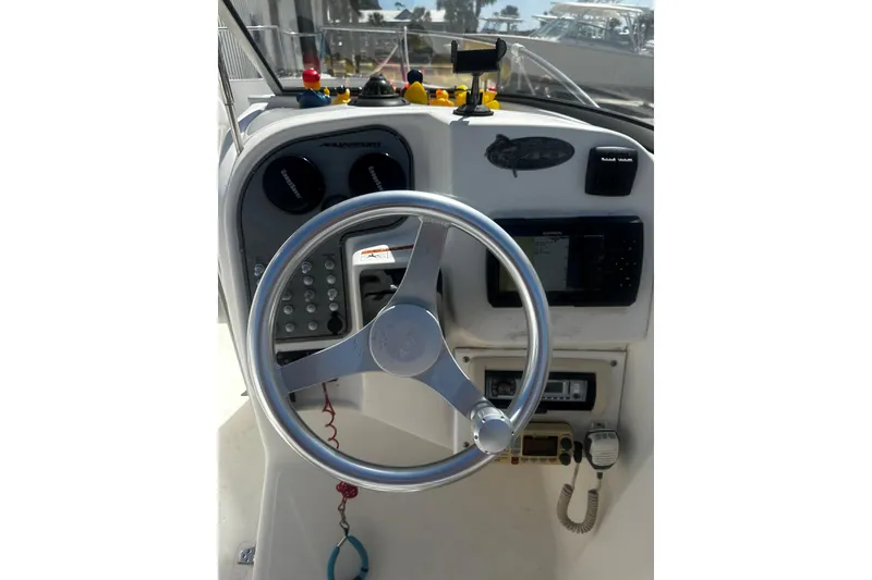 Slide: The Image of Steering console of 2004 Aquasport 215 Osprey Sport boat with navigation instruments. - 10