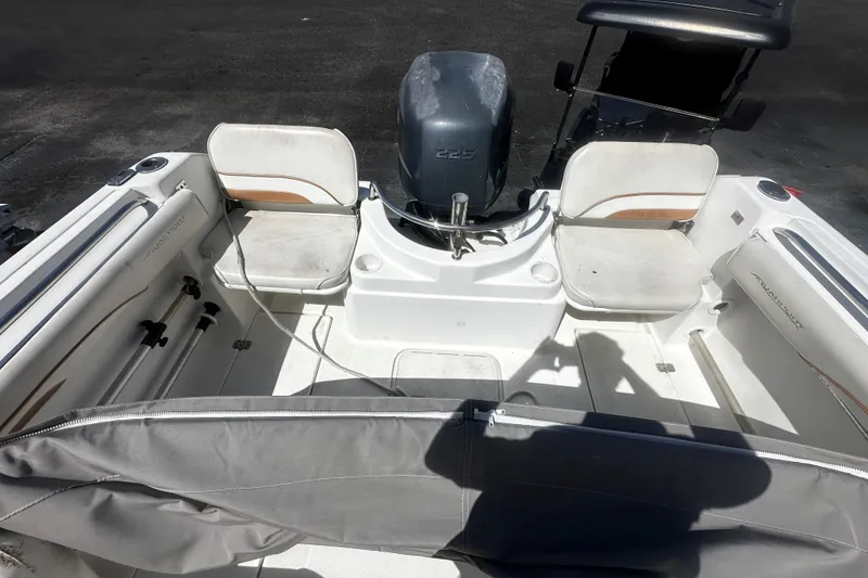 Slide: The Image of 2004 Aquasport 215 Osprey Sport boat interior with seating and motor. - 4