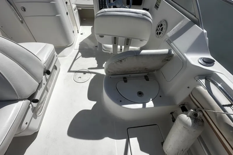 Slide: The Image of Interior of 2004 Aquasport 215 Osprey Sport boat with white seating and storage compartments. - 5