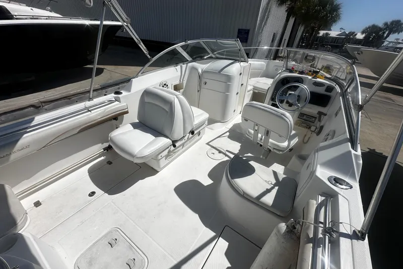 Slide: The Image of 2004 Aquasport 215 Osprey Sport boat interior with white seating and steering console. - 6