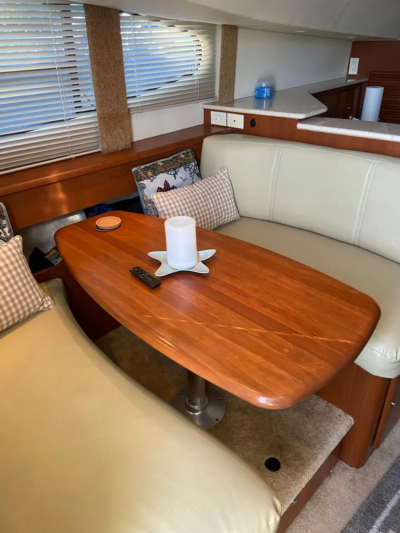 Slide: The Image of 2005 Silverton 330 Sport Bridge boat interior with white seating and cup holder. - 21