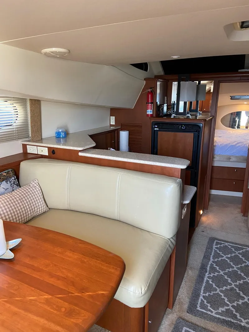 Slide: The Image of 2005 Silverton 330 Sport Bridge boat with white seating and marina view. - 22