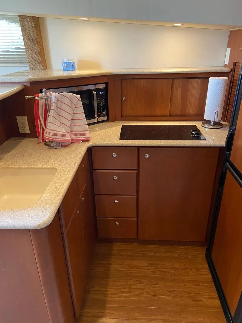 Slide: The Image of Interior of 2005 Silverton 330 Sport Bridge with beige leather seating and nautical decor. - 27