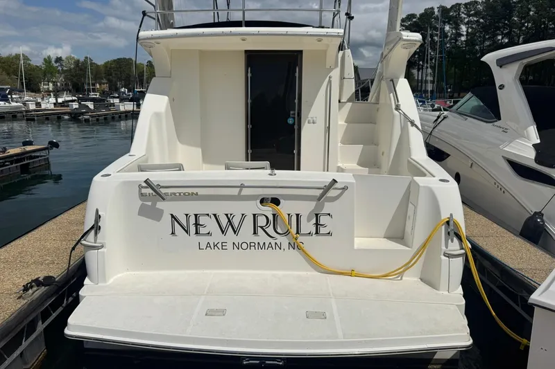 Slide: The Image of 2005 Silverton 330 Sport Bridge yacht docked under a cloudy sky. - 3