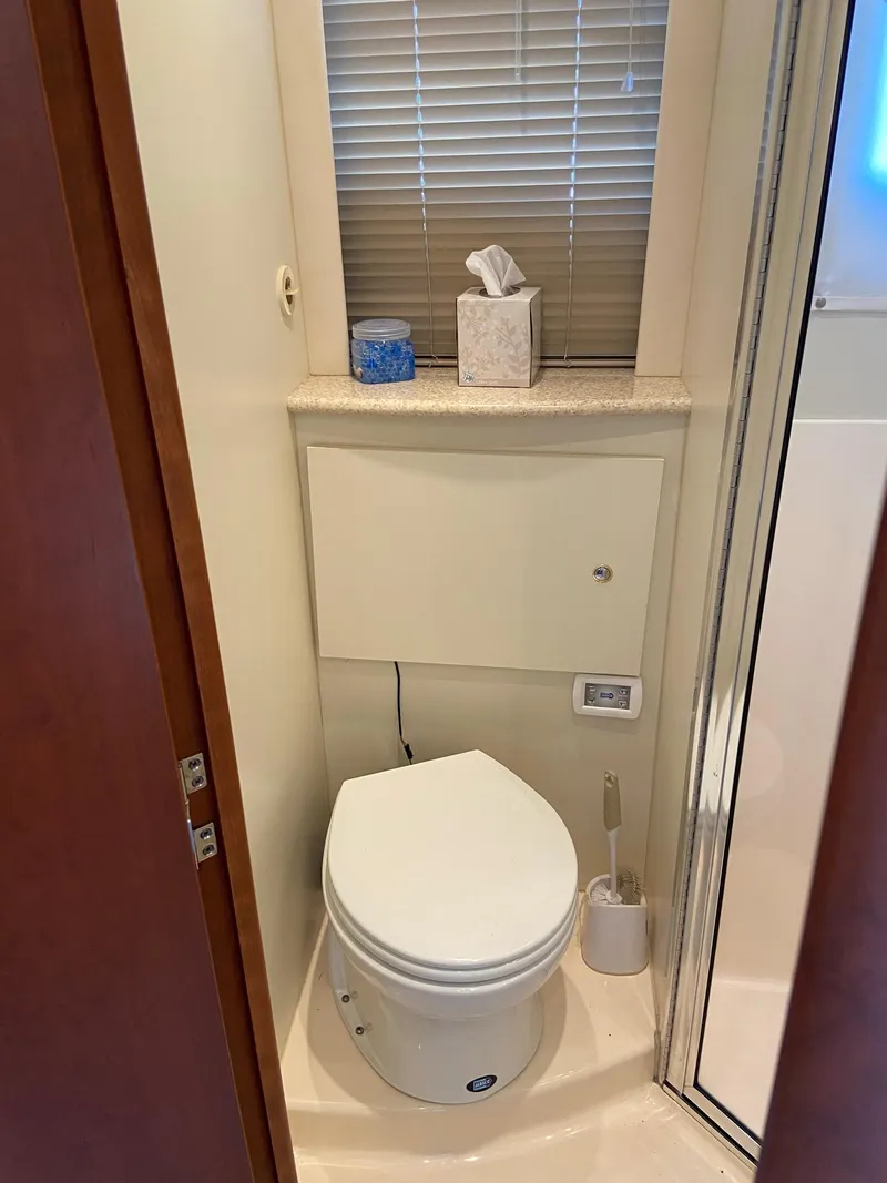 Slide: The Image of Interior of 2005 Silverton 330 Sport Bridge with skylight, TV, and wooden cabinetry. - 30