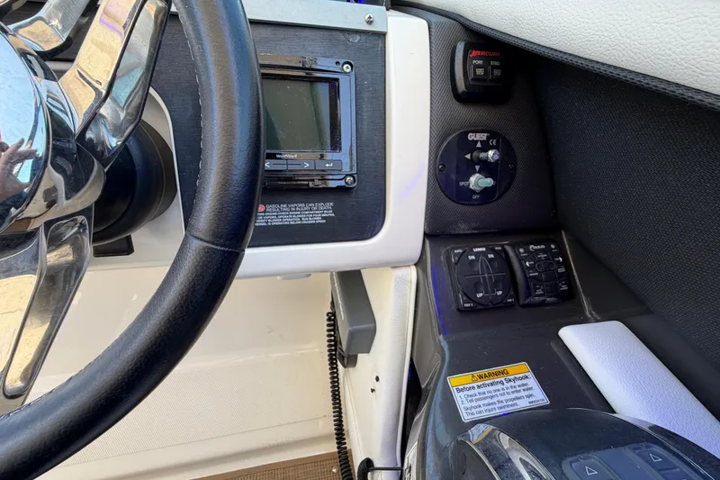 Slide: The Image of Steering wheel and controls of a 2015 Sea Ray SLX 350 boat cockpit. - 13