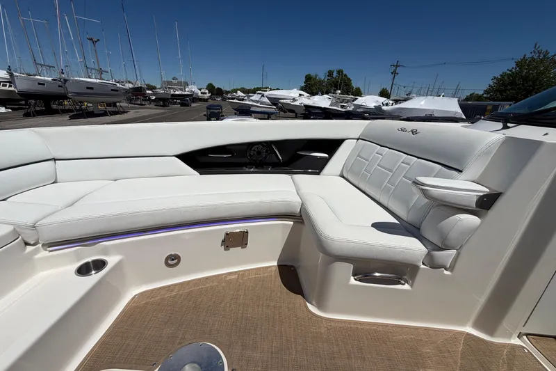 Slide: The Image of Luxurious seating on a 2015 Sea Ray SLX 350 boat, docked with other vessels. - 15