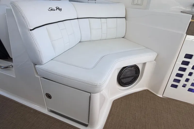 Slide: The Image of White leather seating on 2015 Sea Ray SLX 350 boat, featuring integrated speaker and storage. - 23