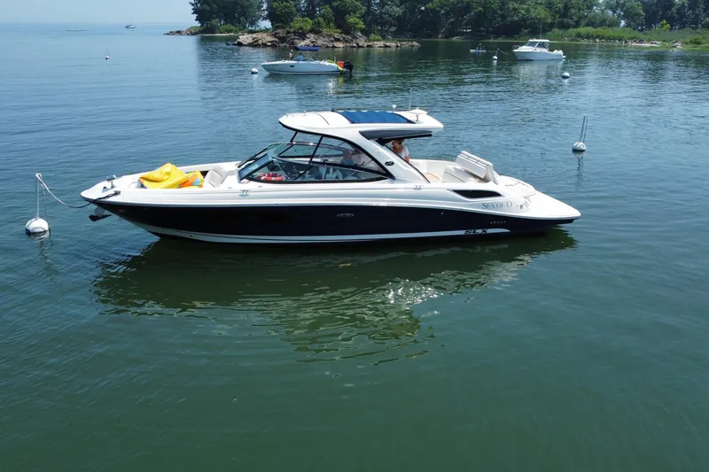 Slide: The Image of 2015 Sea Ray SLX 350 boat anchored on calm water near a shoreline. - 7