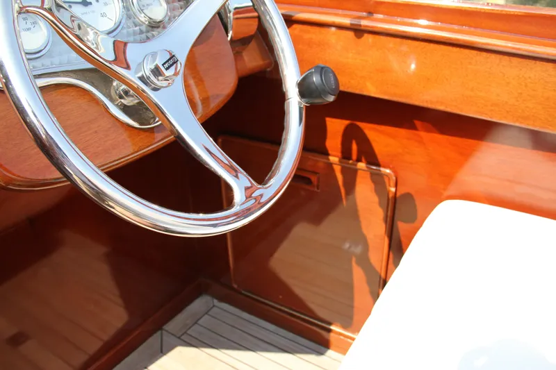 Slide: The Image of Steering wheel of a 2005 Limestone 24' Express Cruiser with polished wood finish. - 16