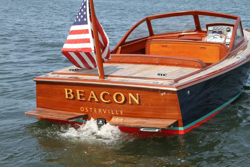 Slide: The Image of 2005 Limestone 24' Express Cruiser with American flag on water, named "Beacon Osterville". - 3