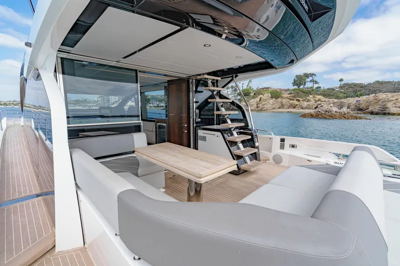 Slide: The Image of 2023 Sunseeker 65 Sport Yacht deck with seating, table, and ocean view. - 11