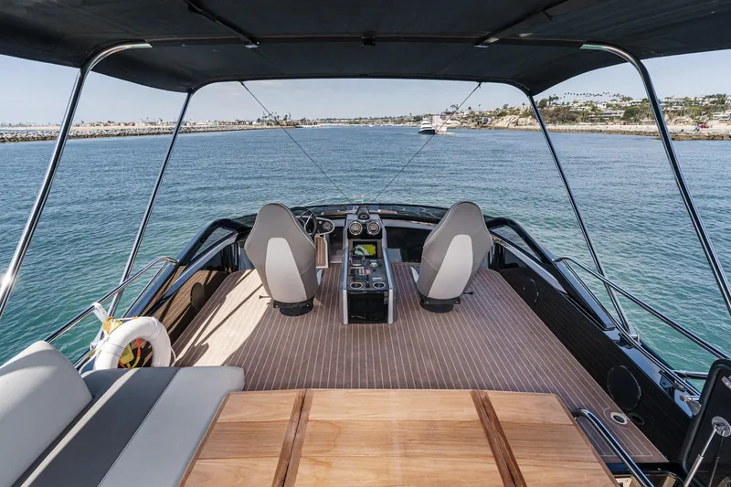 Slide: The Image of 2023 Sunseeker 65 Sport Yacht helm with ocean view, featuring sleek design and modern controls. - 14