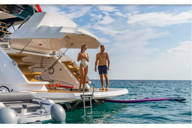 Slide: The Image of 2023 Sunseeker 65 Sport Yacht with people enjoying the swim platform at sea. - 65