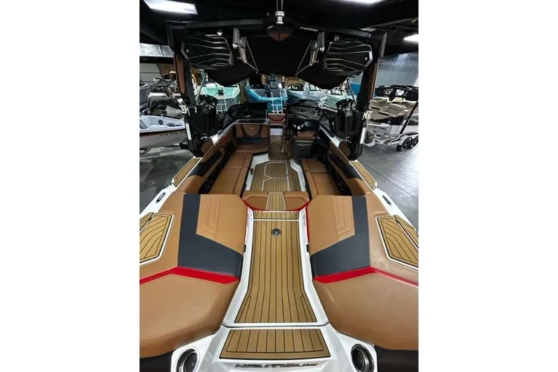 Slide: The Image of 2023 Nautique Super Air Nautique G23 interior with tan and black seating, wood accents. - 6