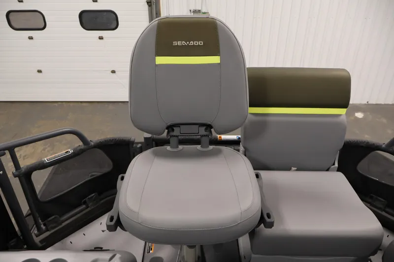 Slide: The Image of 2025 Sea-Doo Switch Fish 21 seat with gray upholstery and lime accents in a garage setting. - 32