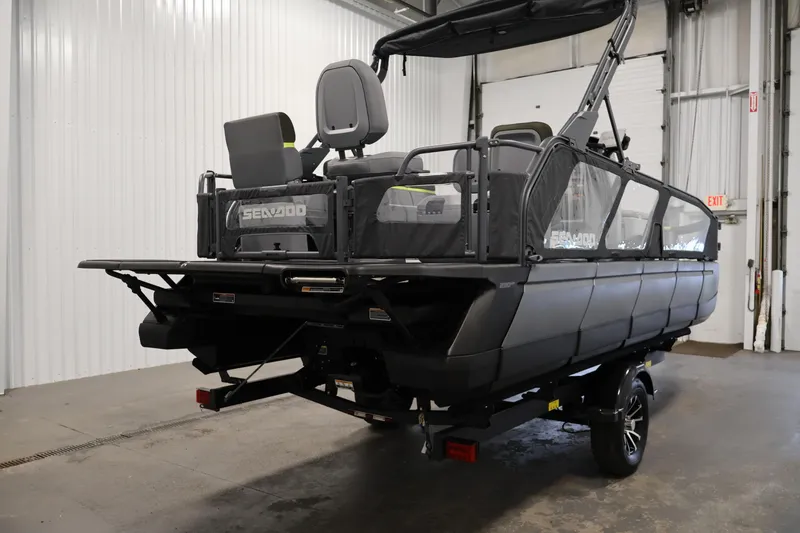 Slide: The Image of 2025 Sea-Doo Switch Fish 21 pontoon boat in a warehouse setting, rear view. - 5