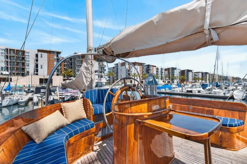 Slide: The Image of Luxurious 1961 Vic Franck Custom yacht interior with polished wood and blue seating at marina. - 1