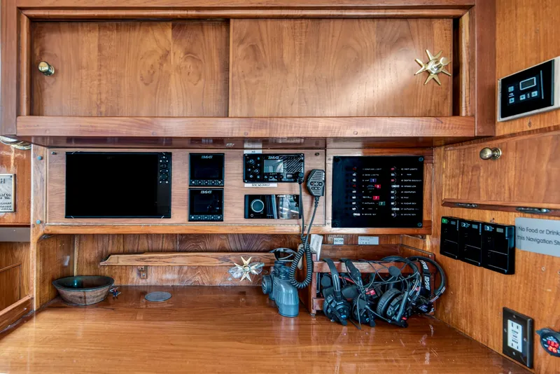 Slide: The Image of 1961 Vic Franck Custom yacht navigation station with wooden cabinetry and modern control panels. - 12